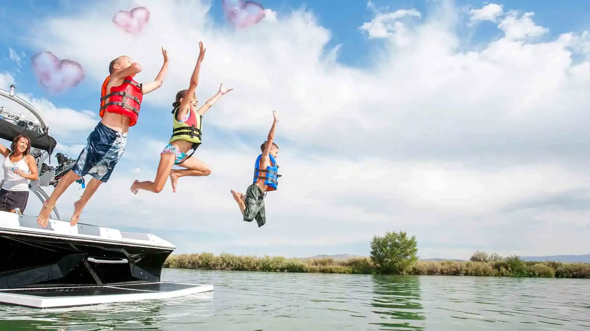 Three kids jumping off back of boat into water.
