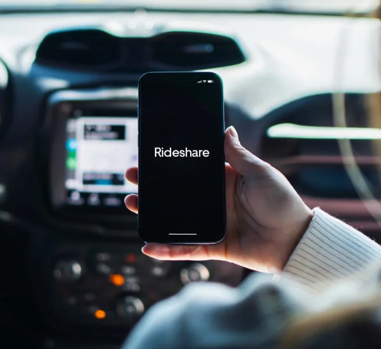 passenger in car holding smartphone that reads rideshare on the screen