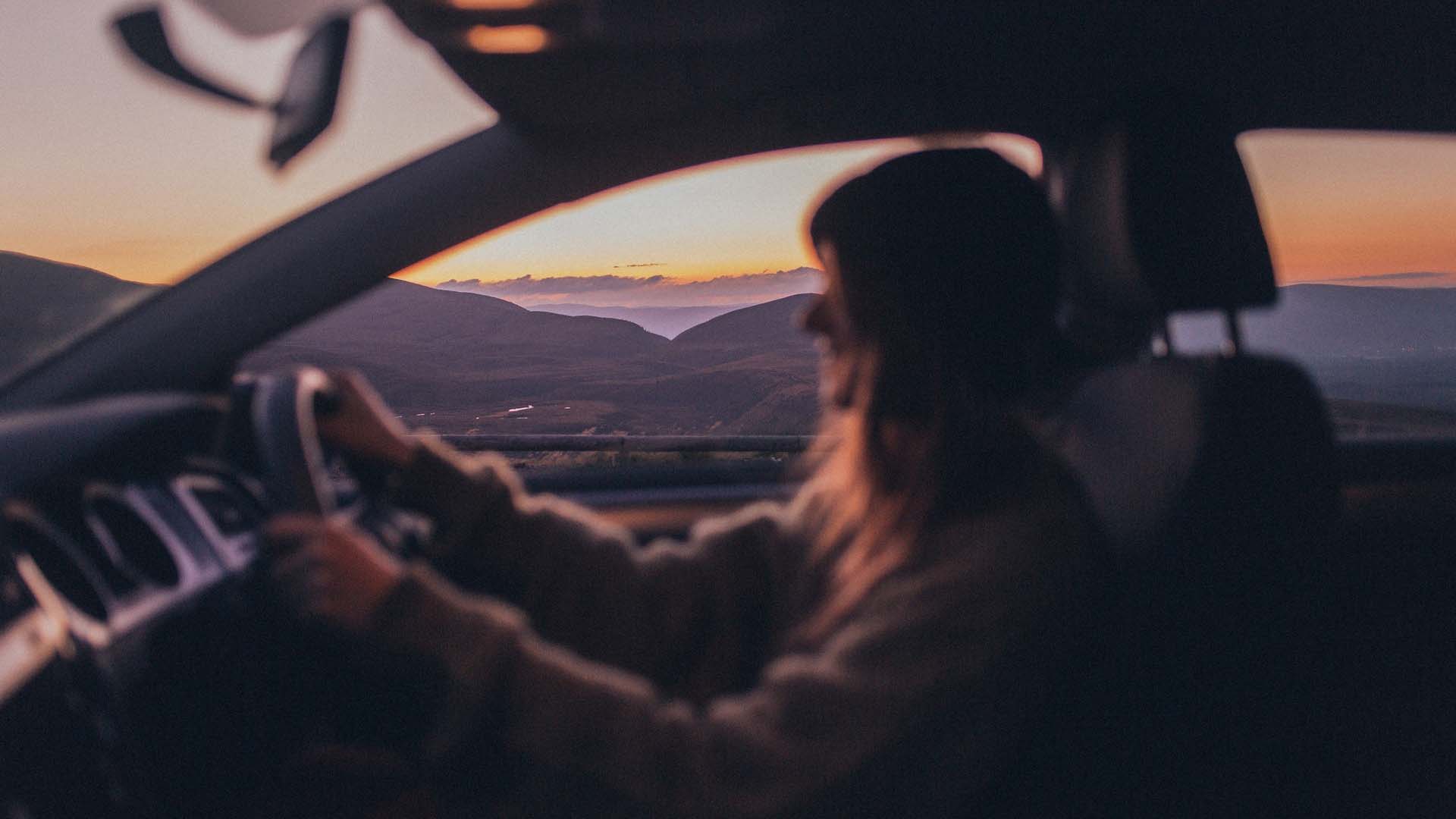 Woman driving at sunset on the west coast