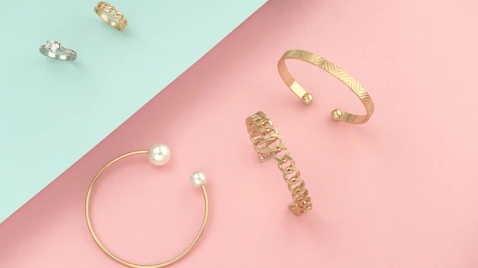 bracelets and rings on pink and blue background