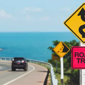 car driving on highway past road trip sign