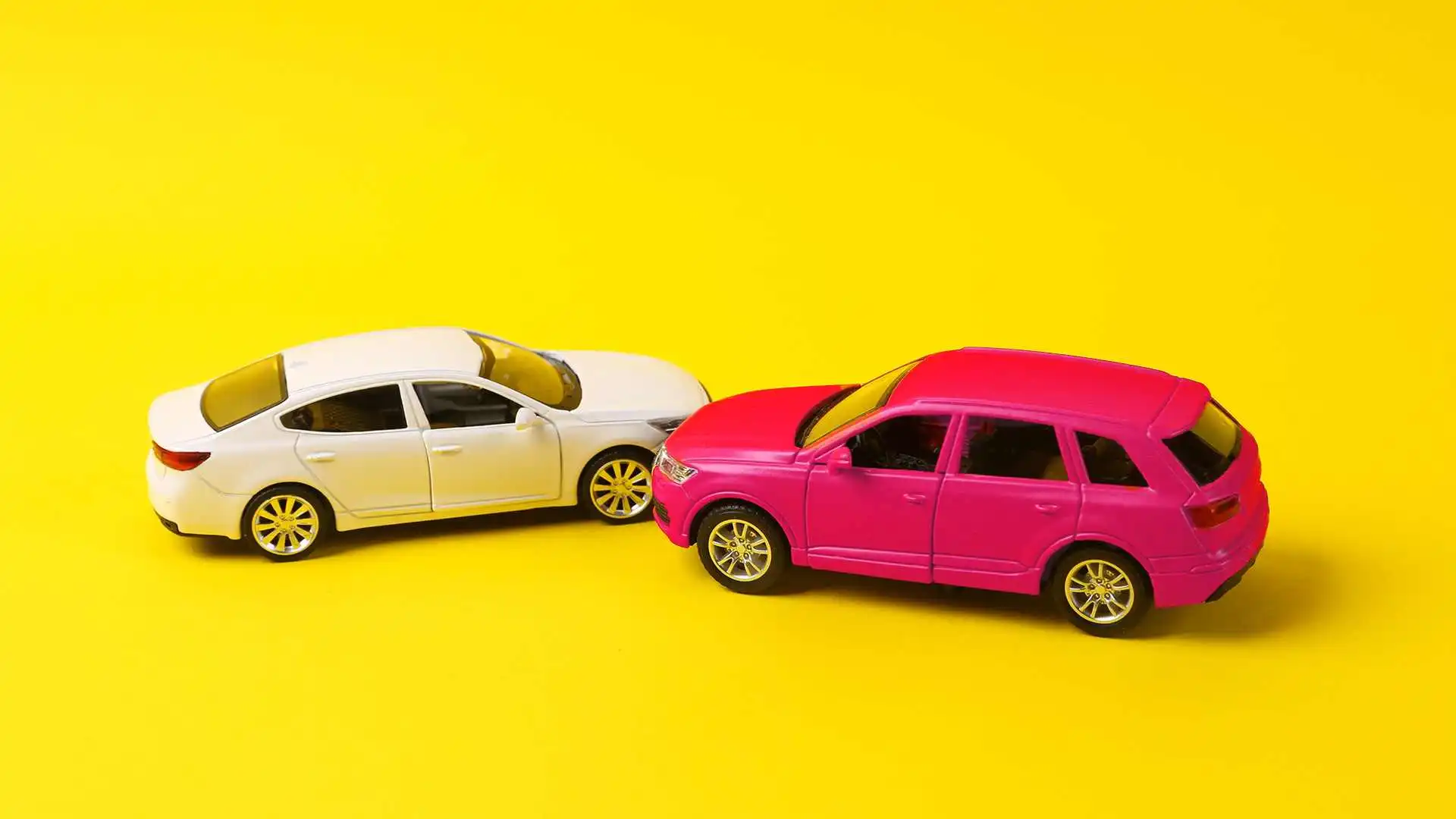 two toy cars posed in a fender bender