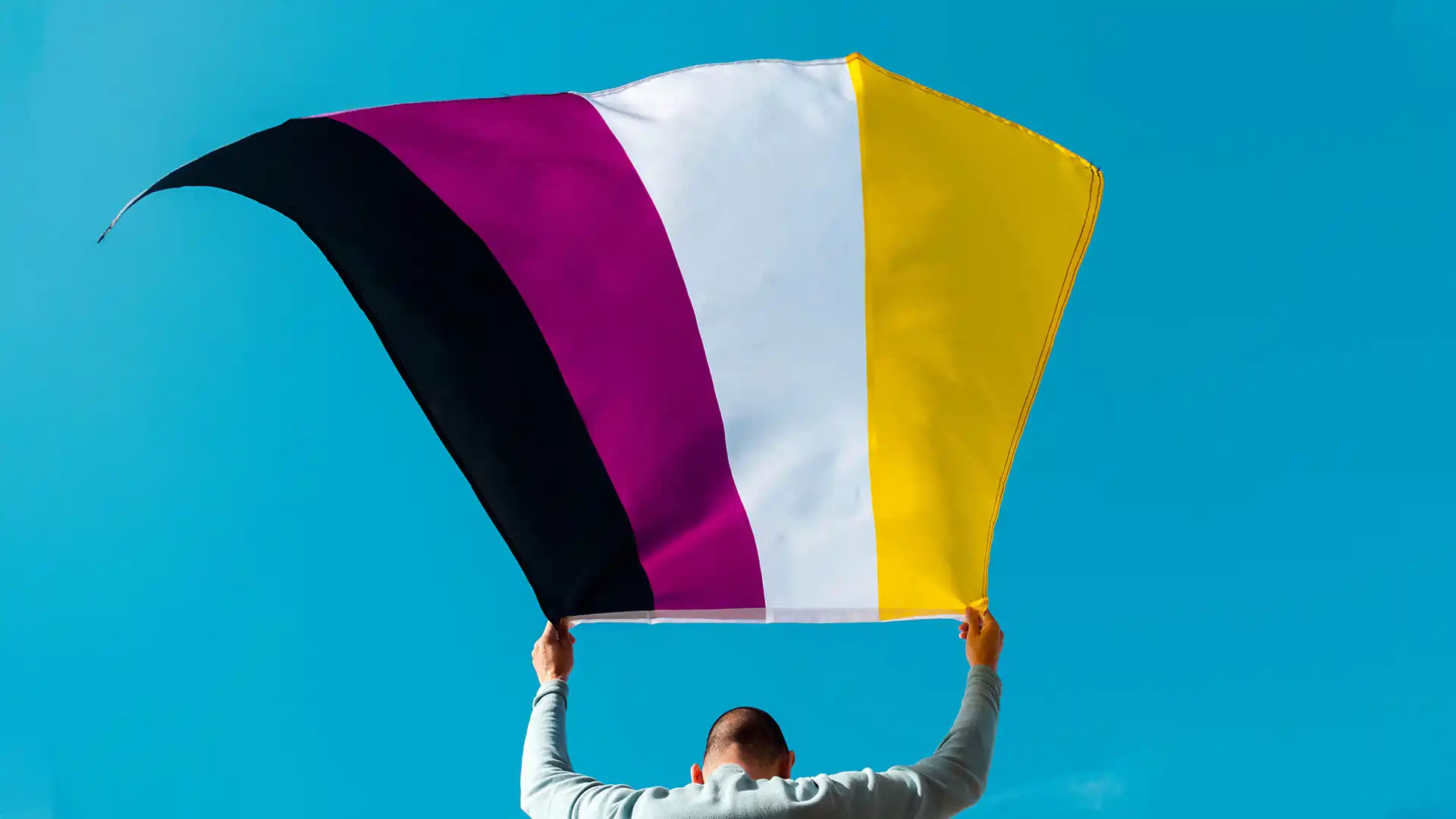 Person waving a non-binary Pride flag