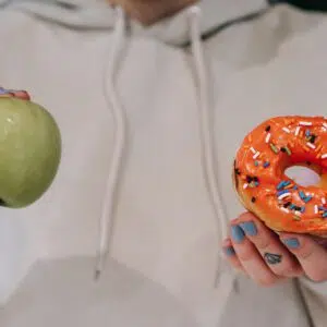 holding up apple and donut