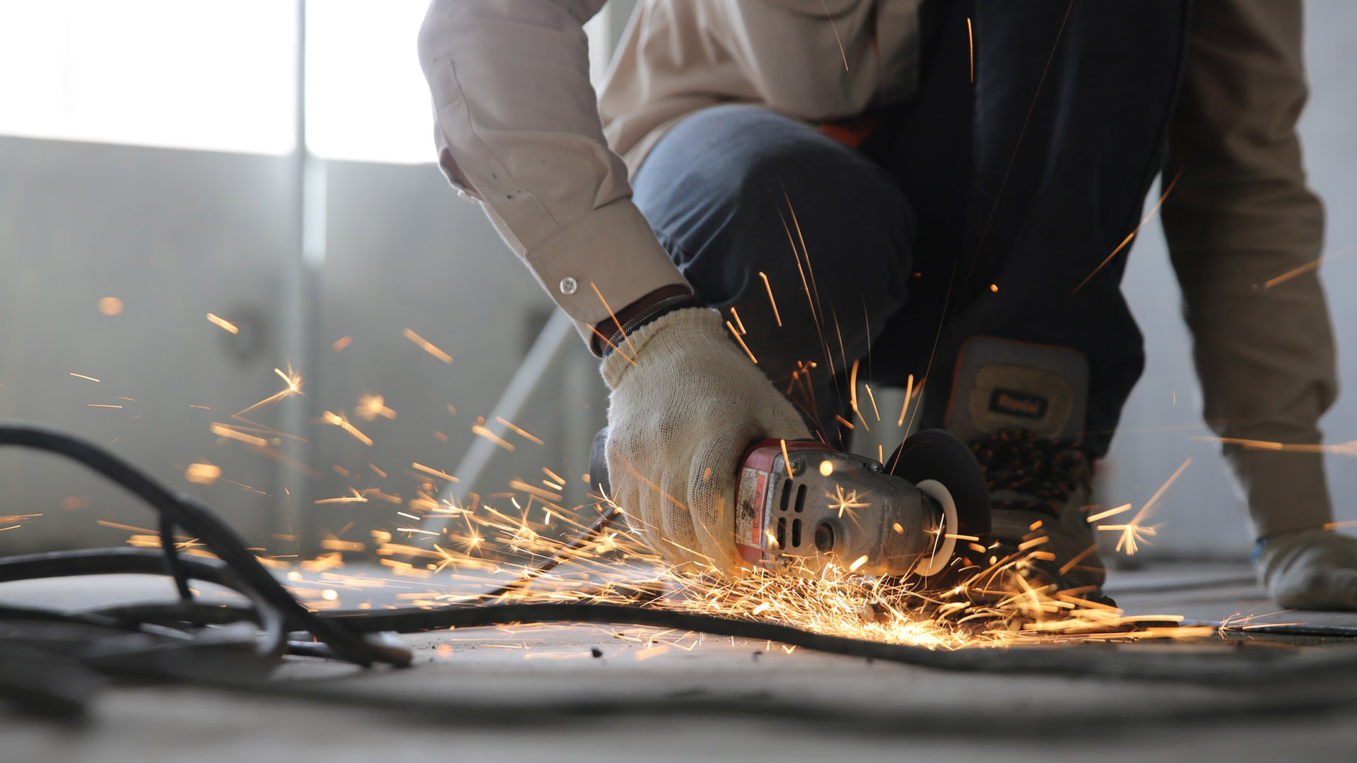 A tradesperson using a circular saw with sparks flying