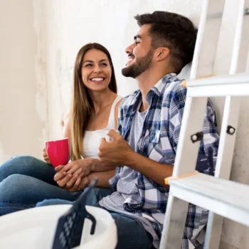 couple sitting laughing while doing home renos