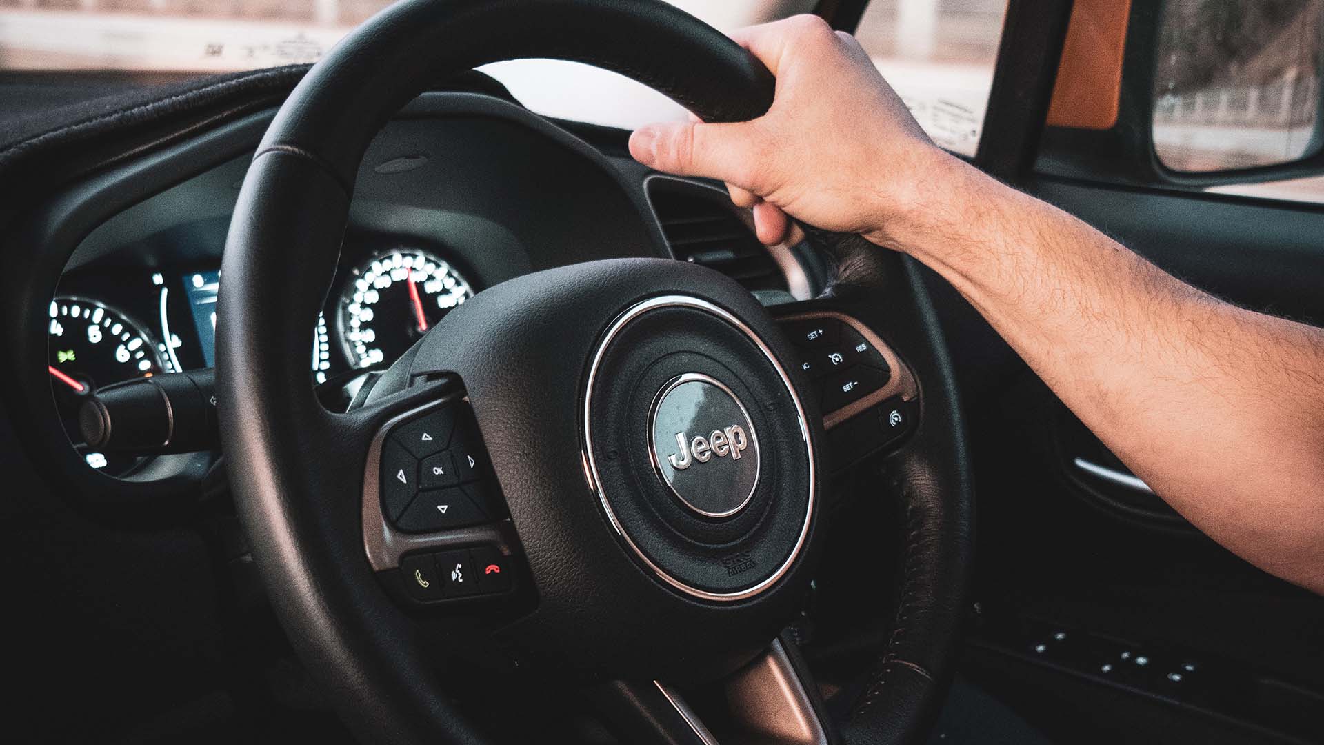 Hand holding jeep steering wheel