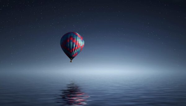 Hot air balloon flying over the water.