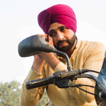 Sikh male on motorcycle wearing turban without a helmet