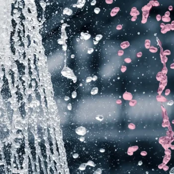 closeup on water flowing out of faucet with water droplets