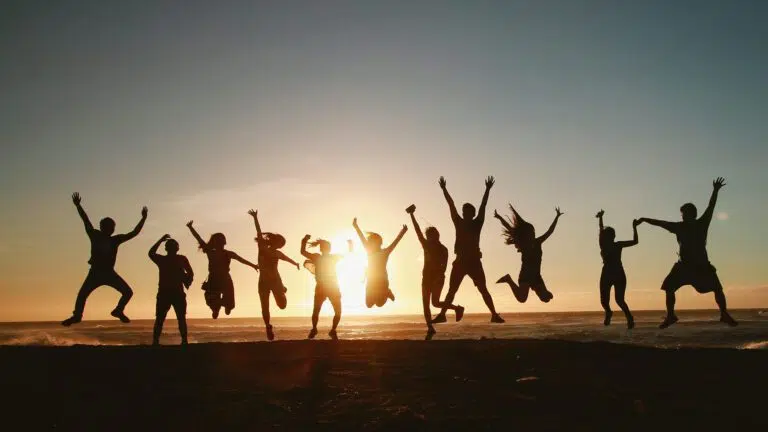 happy team jumping in the sunset