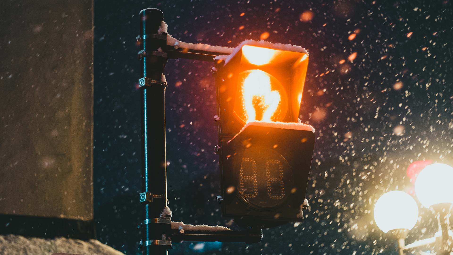 Red hand crosswalk light in a snowy night