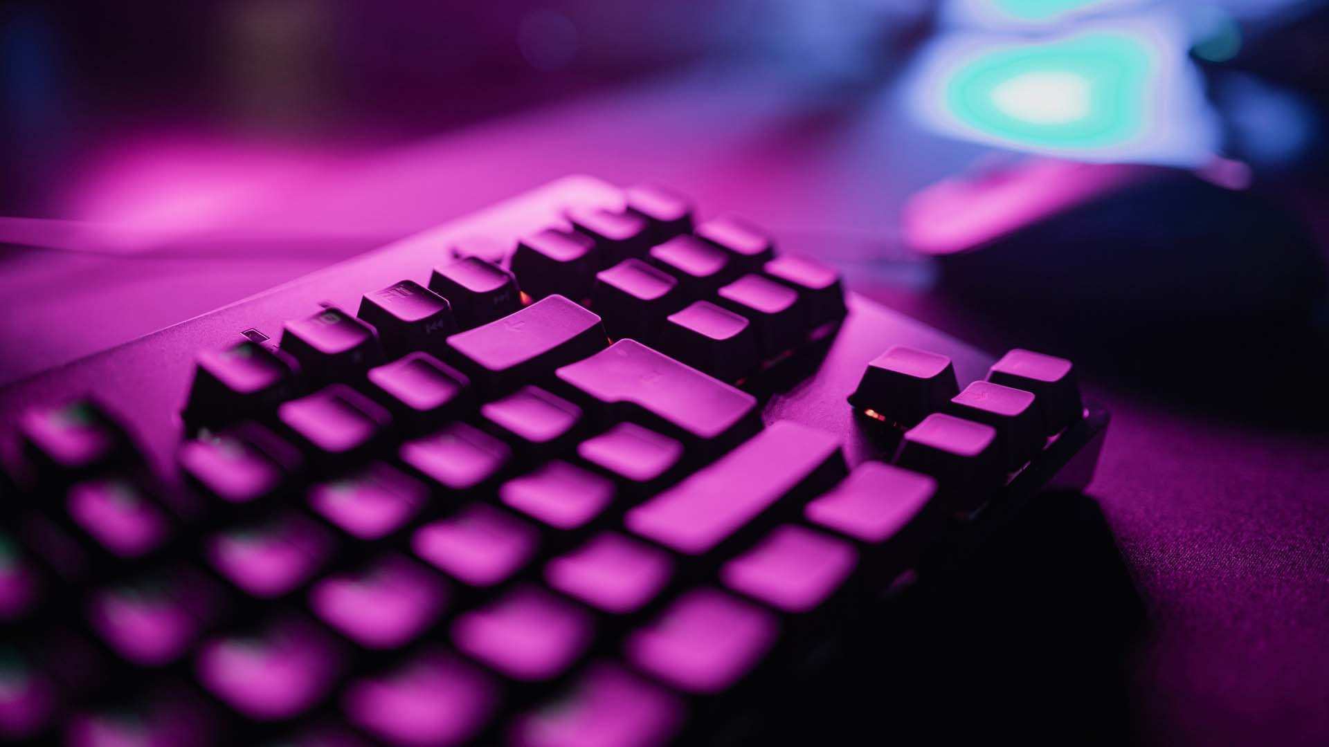 Computer keyboard under purple light