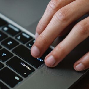 Hands typing on a laptop keyboard