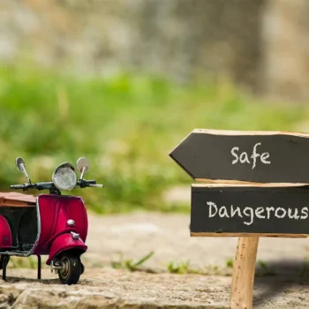 toy moped with sign indicating safety and danger