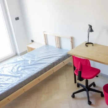 student dorm room with empty bed and desk
