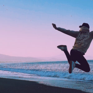 person jumping on a beach in the sunset