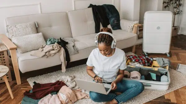 woman using a laptop on the floor wearing headphones