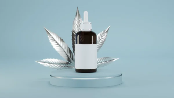 tincture bottle on glass riser with silver cannabis leaf behind