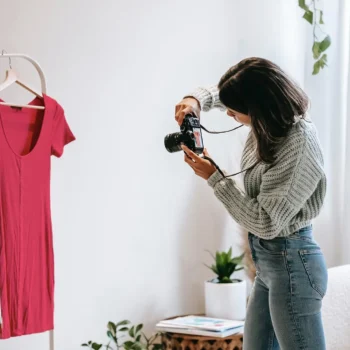 home based clothing designer taking photo of dress
