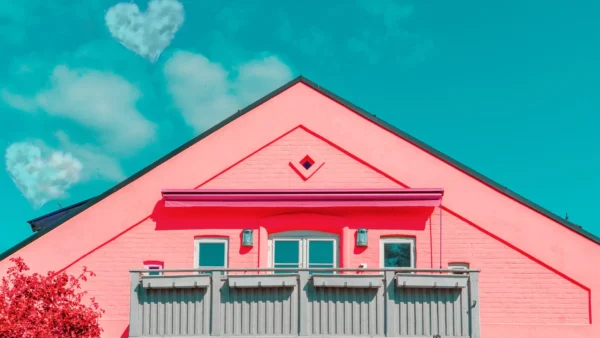 pink house with blue sky and clouds
