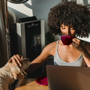 person drinking coffee at home with pet