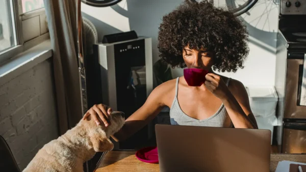 person drinking coffee at home with pet