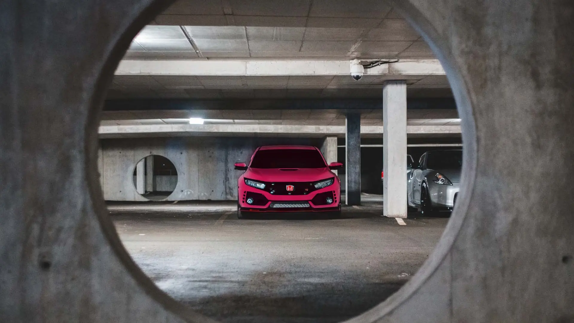 pink car in parking spot in parking garage