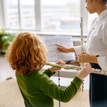 music teacher teaching student playing flute