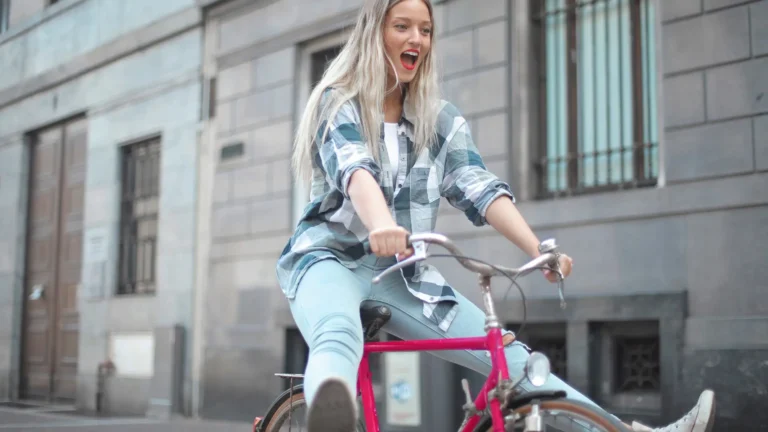 woman riding pink bicycle smiling