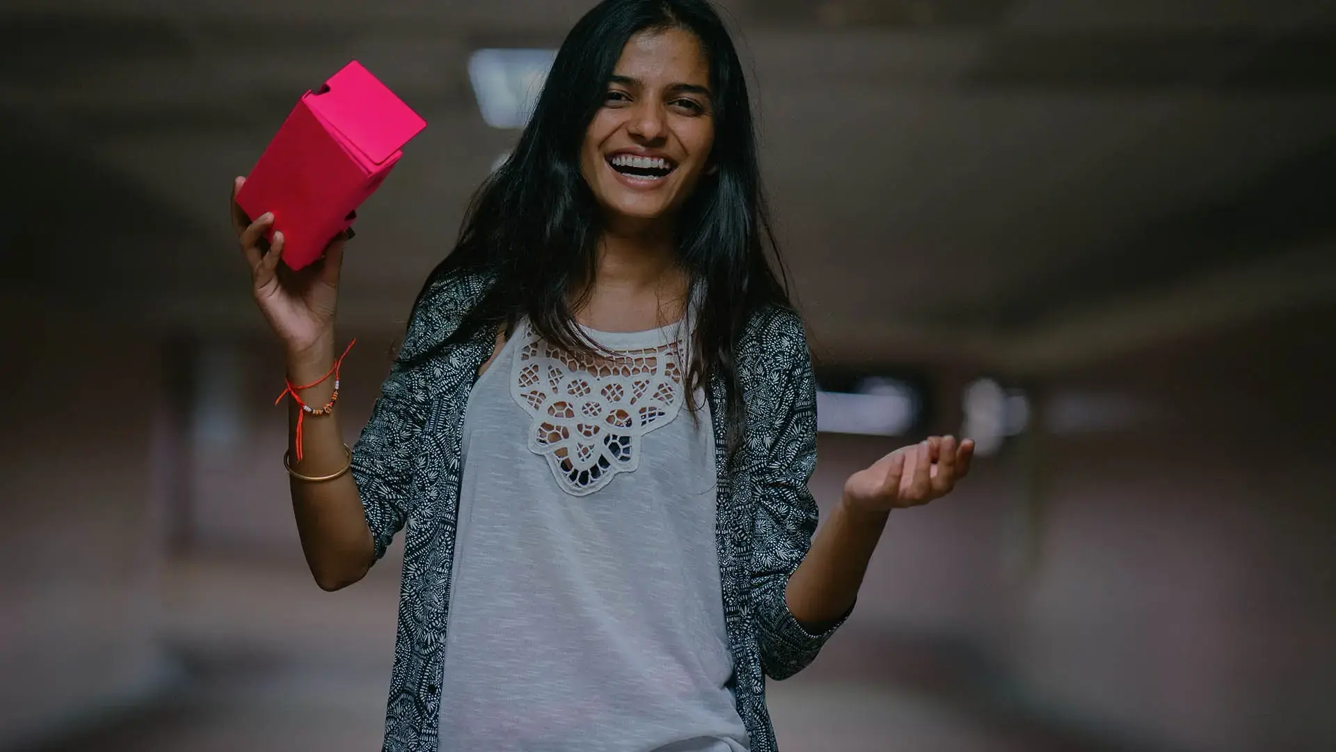 Smiling woman holding a box.