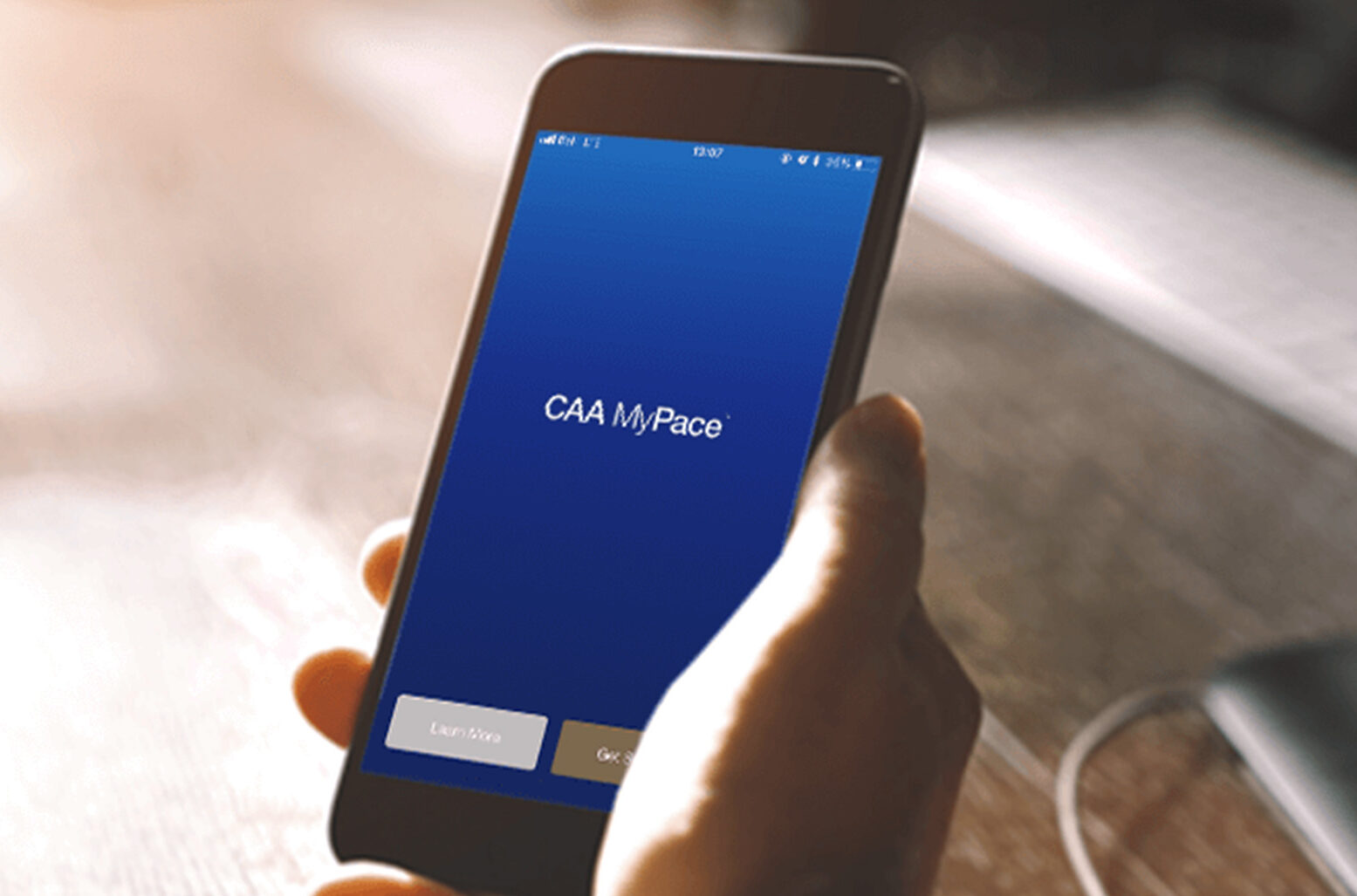 CAA logo on phone screen in hand.