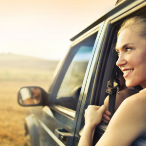 woman leaning out back seat window of vehicle