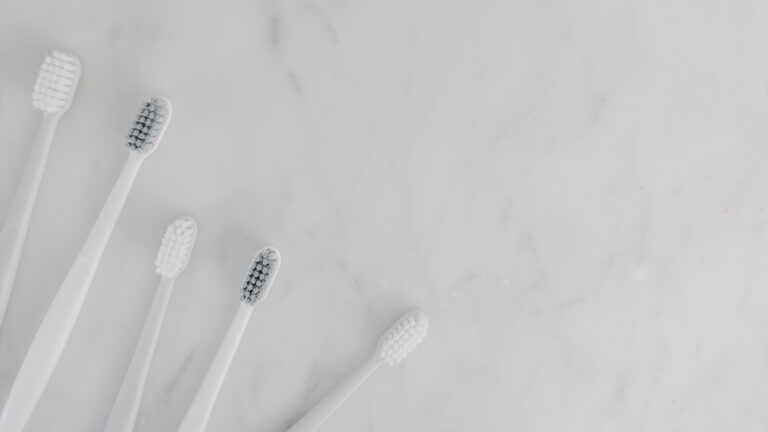 Toothbrushes on marble counter.