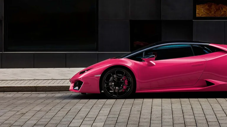 Pink luxury sports car on an empty urban street.