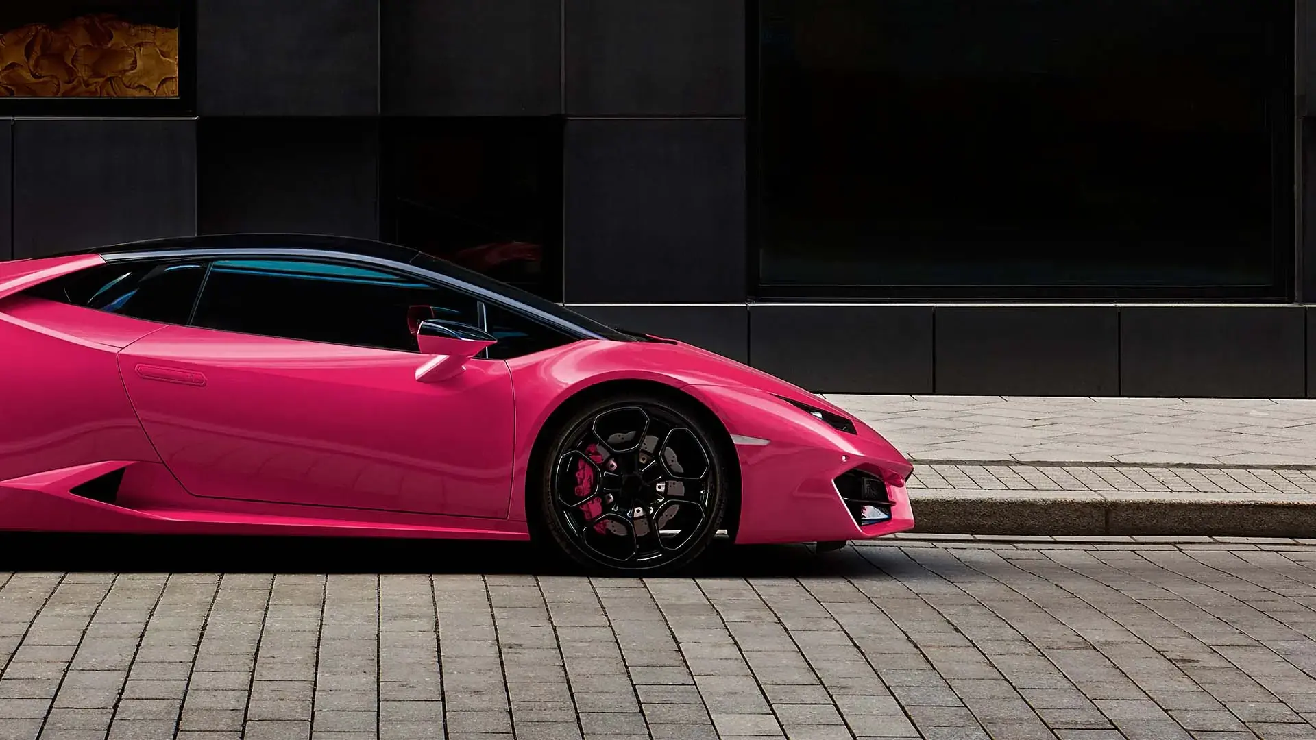 Pink luxury sports car on an empty urban street.