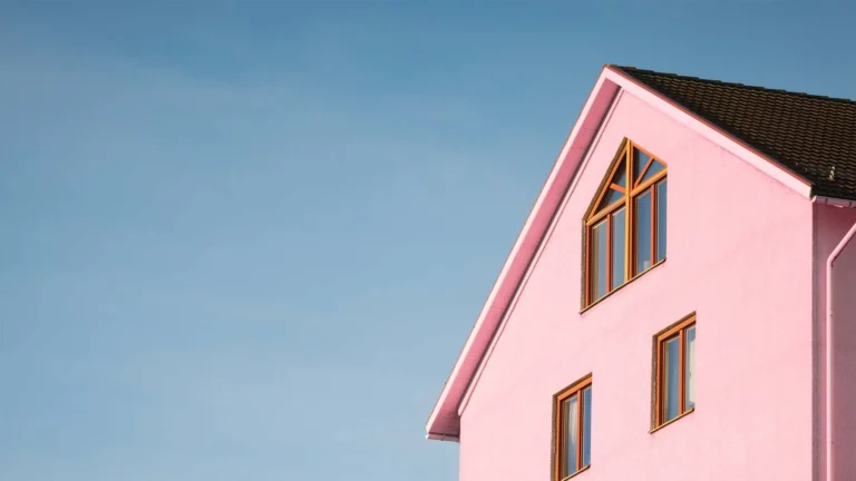 Tall pink house against a clear blue sky.