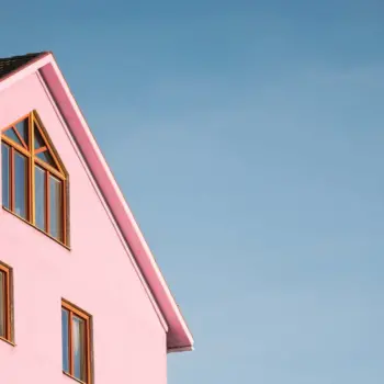 Tall pink house against a clear blue sky.