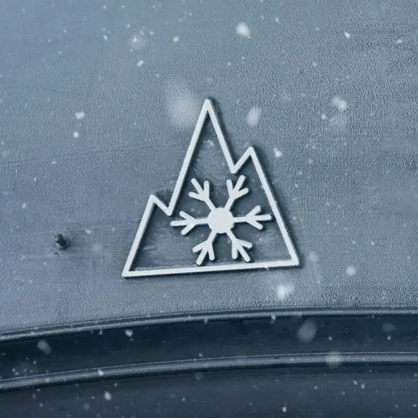 The winter tire symbol, a snowflake inside a three-peaked mountain, on the side of a tire.