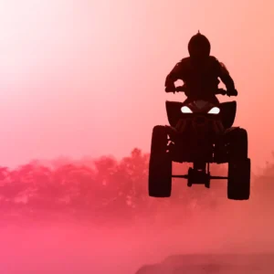 Quad bike jumping in the sunset.