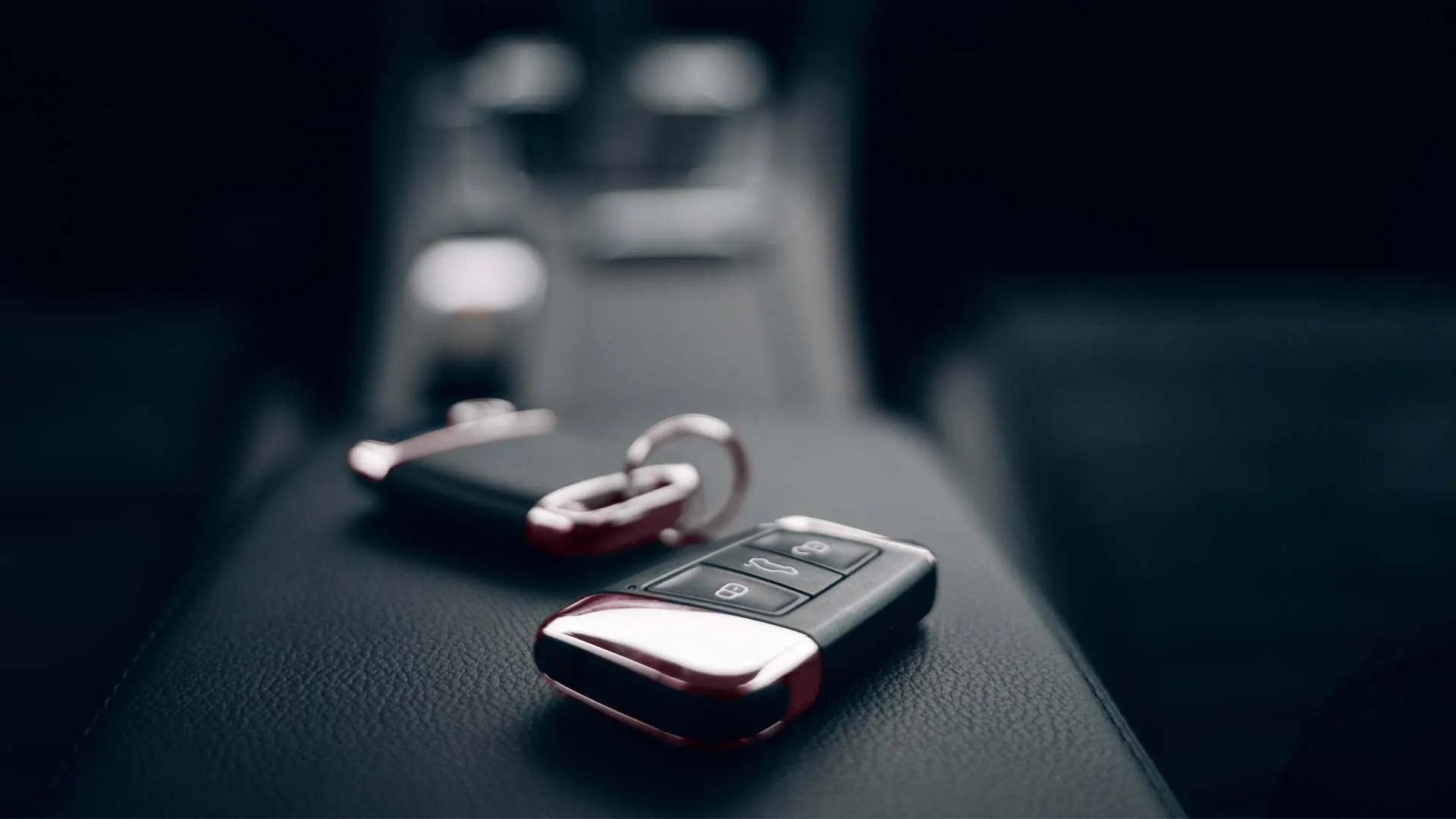 Car keys on the armrest of a rental car.