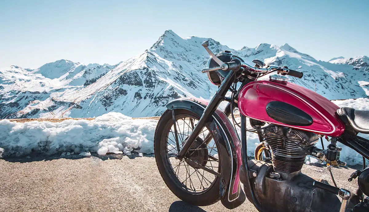 Vintage motorcycle parked with a mountain view.
