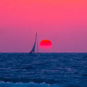 Sailboat in the water at sunset.