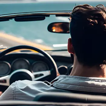 Young man driving in a convertible sports car.