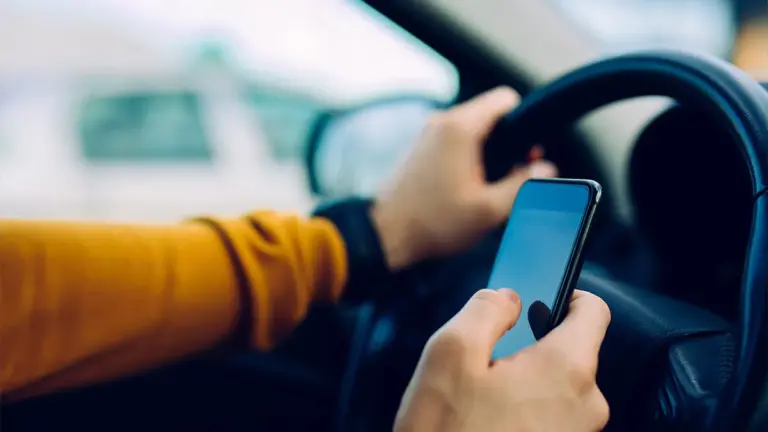 Distracted driver texting while behind the wheel.