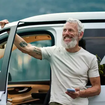 Older man standing outside his car.