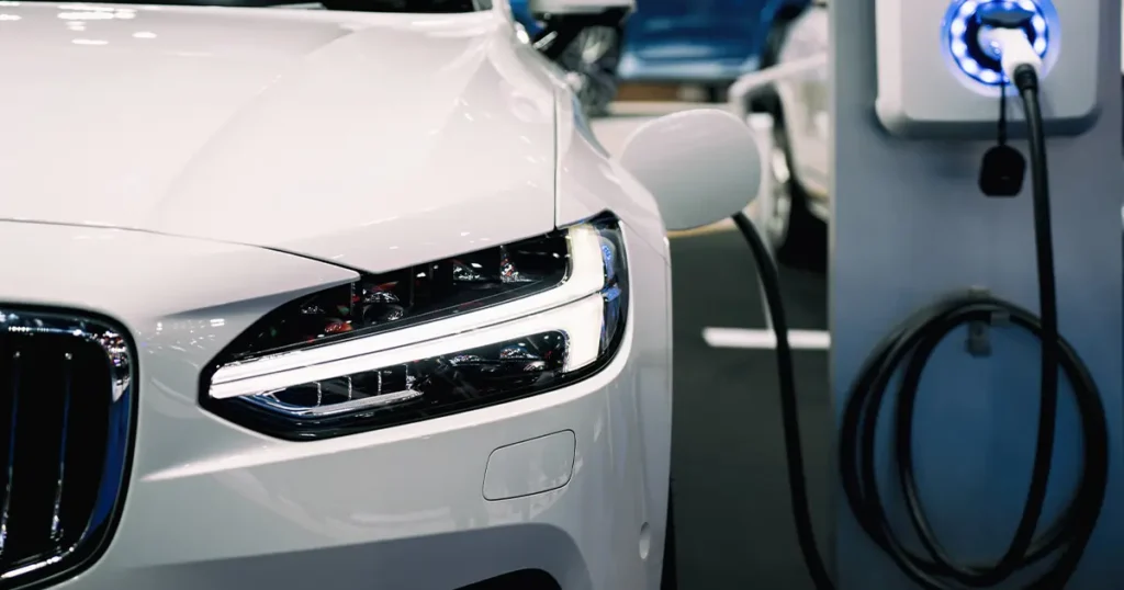 White EV plugged in at charging station